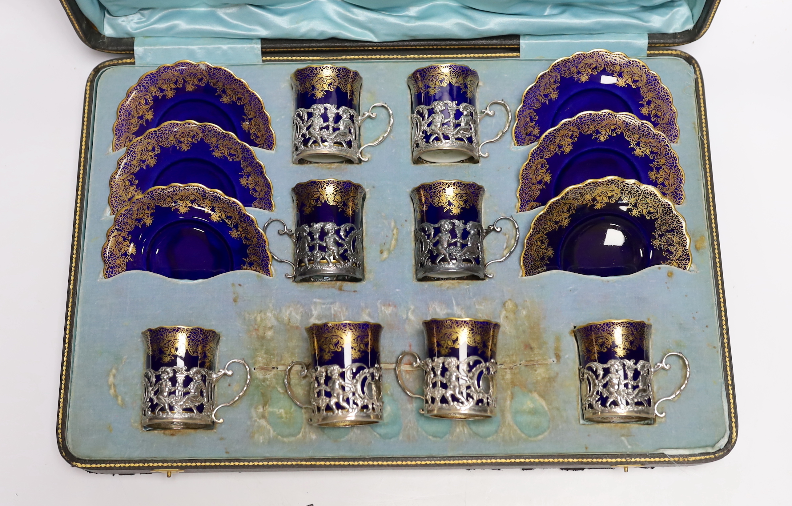 A set of eight Aynsley porcelain coffee cans and saucers, the cans with silver holders, William Hutton & Sons, London, 1905, with fitted case for six (no spoons)